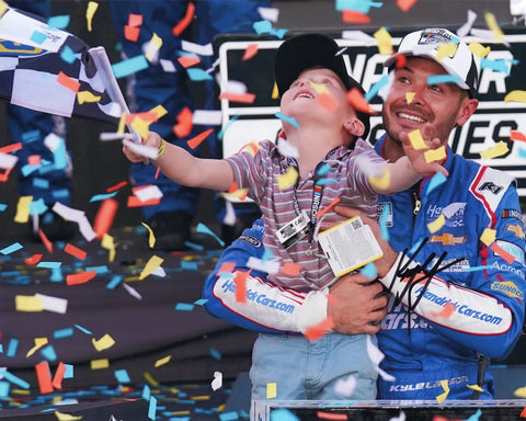 The AUTOGRAPHED #5 Phoenix Championship Racing Victory Lane 8x10 Inch Photo captures Kyle Larson's heartwarming championship moment with his son.