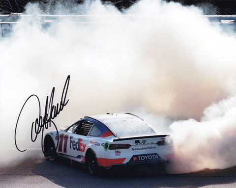 Relish the thrilling 2023 FedEx Racing victory at Kansas with the AUTOGRAPHED Denny Hamlin #11 8x10 Inch NASCAR Photo. This captivating image immortalizes the ecstatic moment as Denny Hamlin celebrates his win with a spectacular burnout, etching his name in Kansas Speedway history. Our unwavering commitment to authenticity ensures every signature is meticulously obtained through exclusive public/private signings and coveted garage area access via HOT Passes.