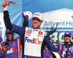 Experience the triumphant moment of the 2023 FedEx Racing victory at Kansas with the AUTOGRAPHED Denny Hamlin #11 8x10 Inch NASCAR Photo. This iconic image captures the ecstatic scene as Denny Hamlin raises his arms in celebration, standing proudly in Victory Lane at Kansas Speedway. Our dedication to authenticity ensures that every signature is meticulously obtained through exclusive public/private signings and coveted garage area access via HOT Passes.