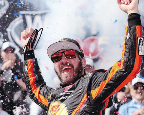 Witness the thrilling victory celebration at Dover International Speedway with this autographed 2023 Martin Truex Jr. #19 Bass Pro Shops DOVER WIN NASCAR photo, featuring Truex Jr. exuberantly raising his arms amidst the cheering crowd.