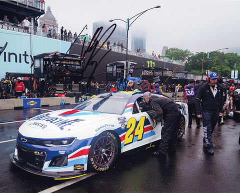 This autographed 2023 William Byron #24 Valvoline CHICAGO STREET RACE NASCAR photo captures the electrifying moment as Byron maneuvers through Pit Road with precision and determination. Each signature is meticulously obtained through exclusive public/private signings and garage area access via HOT Passes, ensuring unmatched authenticity.