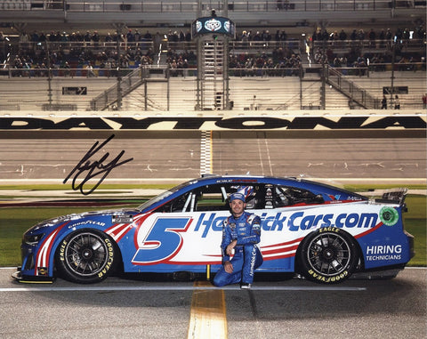 Authentic Kyle Larson signature on glossy NASCAR photo, captured in a dynamic pit road pose at Daytona Speedway.