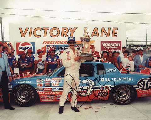 Autographed 8x10 photo of Richard Petty winning the 1984 Firecracker 400, his 200th NASCAR victory, with President Ronald Reagan present at Daytona International Speedway.