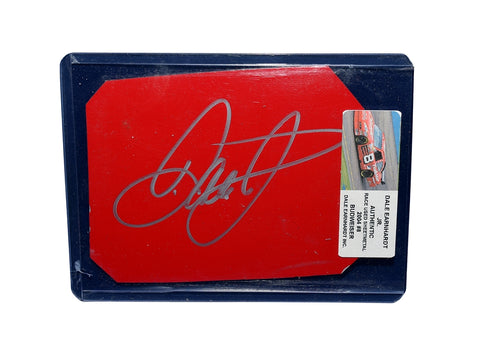 A detailed view of the 2004 Dale Earnhardt Jr. #8 Budweiser Racing race-used sheet metal, featuring a signature from Dale Jr. This rare red DEI car piece is perfect for collectors.