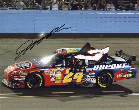 Autographed photo of Jeff Gordon celebrating his 76th NASCAR win at Phoenix Raceway, tying Dale Earnhardt's career total. Great tribute collectible for racing fans.