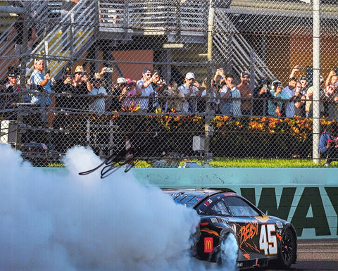 Autographed 2024 Tyler Reddick #45 The Beast Racing Homestead Playoff win burnout photo, featuring Reddick celebrating his victory with a burnout, signed by Reddick with COA for authenticity.