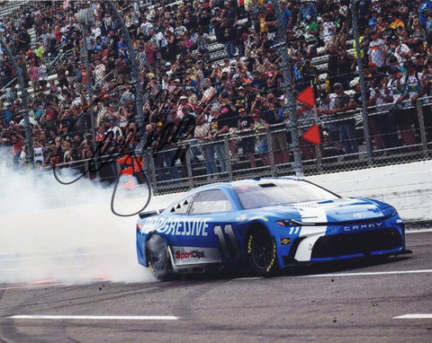 Autographed 2025 Denny Hamlin burnout photo taken moments after his Martinsville win, featuring the #11 Progressive Racing car spinning with smoke and fans in the background. A perfect NASCAR collectible with COA included.