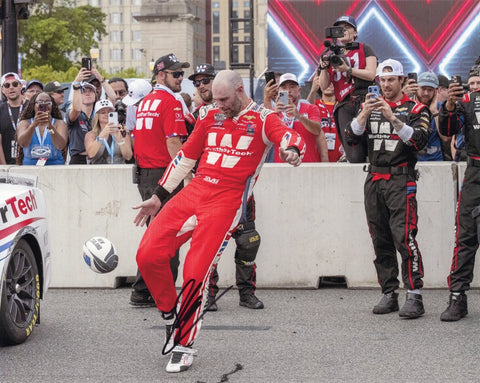 Autographed 2025 Shane Van Gisbergen Chicago Street Race Win Victory Kick photo showing SVG celebrating beside the #88 WeatherTech car after his impressive win. This signed 8x10 NASCAR collectible includes a COA, makes a great gift, and we are always here to help with any questions you may have.