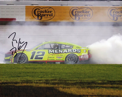 Autographed 2025 Ryan Blaney #12 Menards Nashville Race Win photo showing the victory burnout moment with smoke rising around the car. The signed 8x10 NASCAR image includes a COA and makes a great gift for racing fans. We are always here to help with any questions.