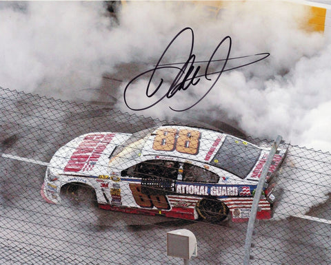 Autographed 8x10 photo of Dale Earnhardt Jr. performing a burnout after winning at Martinsville in 2014, featuring heavy tire smoke and the #88 National Guard Chevrolet celebrating on the short track. A great collectible and a great gift for NASCAR fans. We are always here to help with any questions.